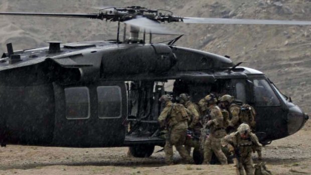 Fatal mission: US soldiers carry the remains of a fallen comrade  near the scene of a helicopter crash in Nangarhar province.