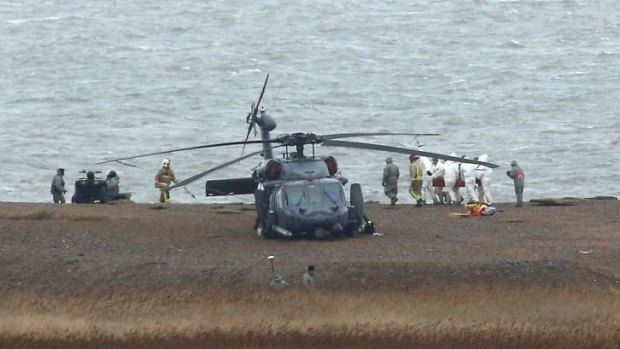 The recovery effort ... emergency services attend the scene after a US Air Force helicopter crashed on marshland near Norlfolk, England on Thursday.