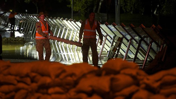 Members of the military construct a new levee after initial attempts failed.