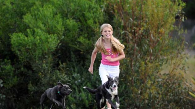 Maddison Watkins, today, aged 11 with her dogs Skye and Cloudy.
