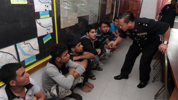 A Malaysian security officer interrogates the survivors of the boat accident. Five people are still missing.