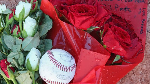 A floral tribute rests on the home plate at the Essendon Baseball Club in Melbourne. placed there in the days after he was gunned down in Oklahoma.