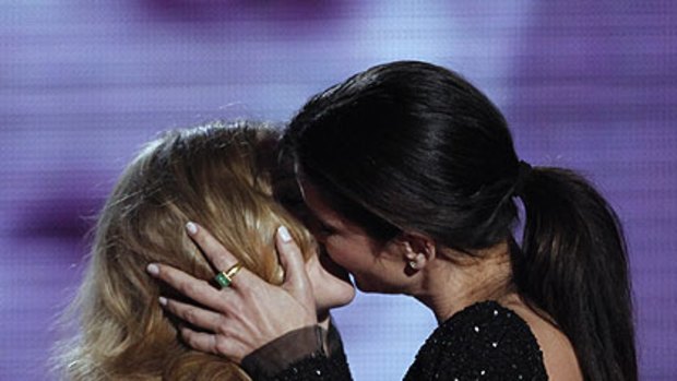 Scarlett Johansson, left, and Sandra Bullock kiss on stage at the MTV Movie Awards.