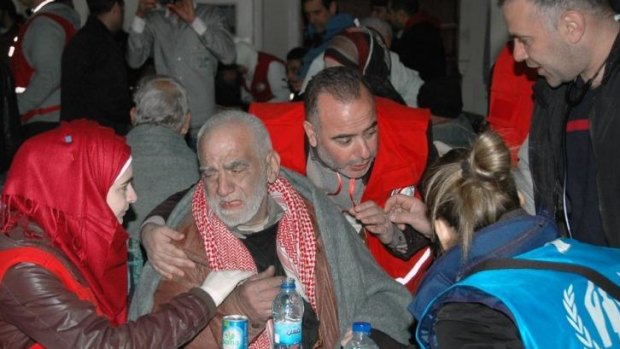 Relief: A Syrian man receives food from Red Crescent workers upon his evacuation from an area of Homs under siege.