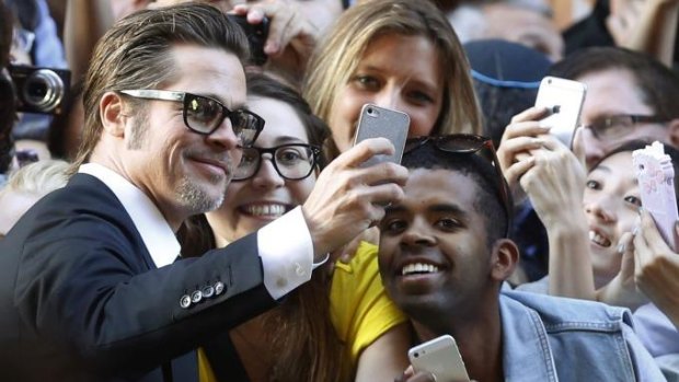 Brad Pitt spends some time taking selfies with fans at the Unbroken premiere in Sydney. 
