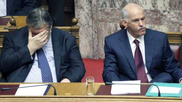 Greek Prime Minister George Papandreou, right, and Finance Minister Evangelos Venizelos show the strain during a confidence vote meeting at the parliament in Athens.