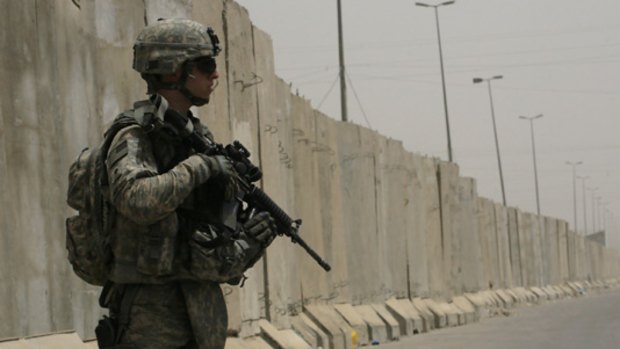 A US soldier on patrol in the Shiite enclave  of Sadr City in Baghdad.  The four-metre-high concrete wall in the background runs for five kilometres through the enclave. PICTURE: AP