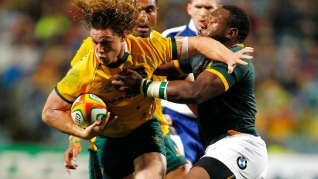 Captain fantastic: Michael Hooper of the Wallabies fends off a tackle by Tendai Mtawarira of the Springboks.