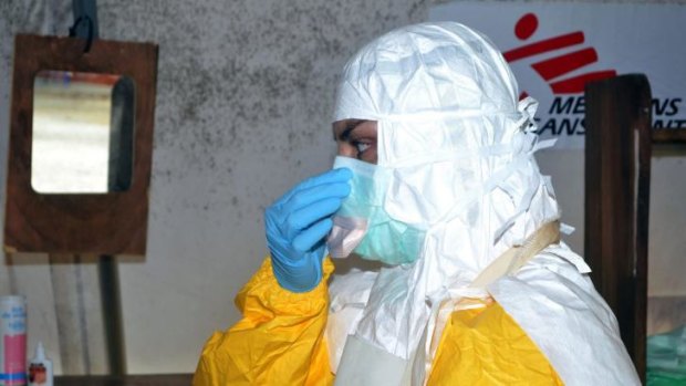 A doctor puts on protective gear at the isolation ward of the Donka Hospital in Conakry. 