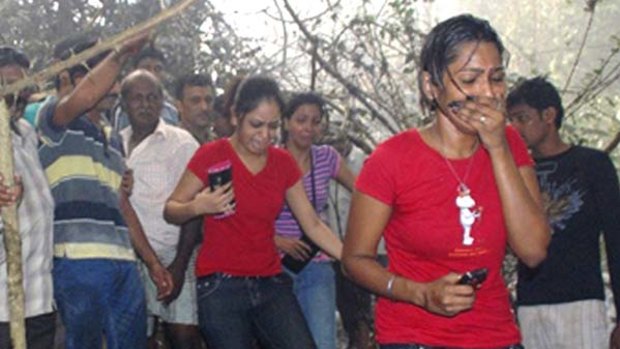 Local residents react after seeing the site of a plane crash in Mangalore in which 159 people are believed to have died.