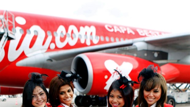 Flight attendants pose by AirAsia X's Airbus A340.