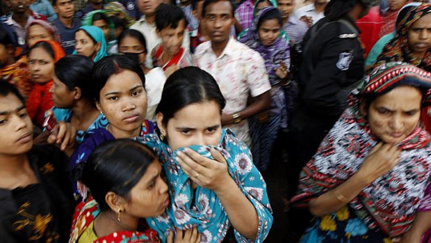 Anxious wait ... people gather outside the burnt garment factory outside Dhaka, Bangladesh, where more than 100 people died on Sunday.