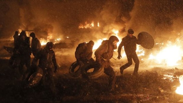 Protesters throw tires in a fire as they clash with police in central Kiev, Ukraine.