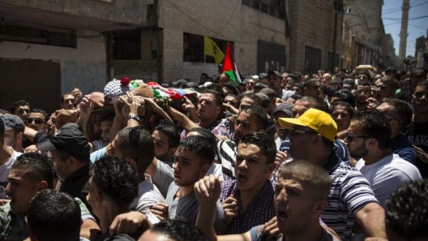 The body of Mohammed al-Araj is carried through the streets to the cemetery during his funeral on July 25 near Ramallah, West Bank.