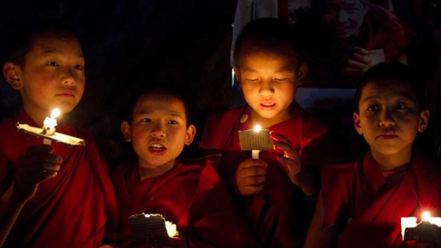 Novice monks hold a candlelight vigil to protest against violence by Chinese police against Tibetan demonstrators.