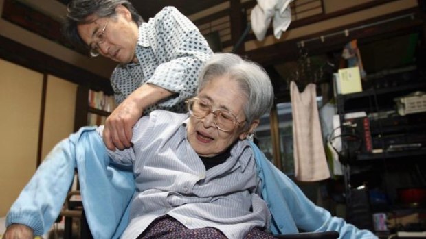 Hiromichi Takeuchi helps his 93-year-old mother Iyo. Japan is to look at robotics to assist look after its ageing population.