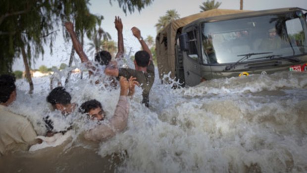 Heaven's floodgate ... evacuees leap to safety as a Pakistani army relief truck ploughs through the  torrent. More rain is forecast to hit the devastated region.