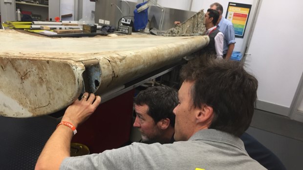 Malaysian and Australian investigators examine the piece of aircraft debris found on Pemba Island off the coast of Tanzania.