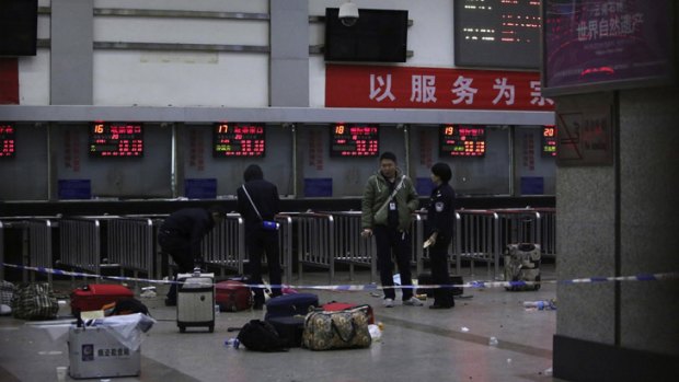 Police stand near luggage left at the ticket office after a group of armed men attacked people at Kunming railway station, Yunnan province.