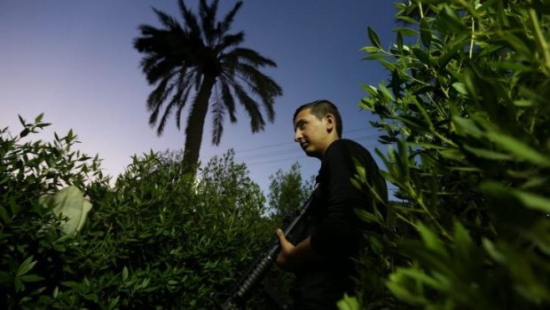 Defending Iraq: A fighter with the Shiite Imam Ali Brigade guards its headquarters in Baghdad.