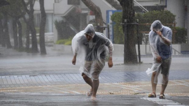People struggle against strong wind and rain caused by Typhoon Vongfong as they wallk on a street in Naha on Japan's southern island of Okinawa.