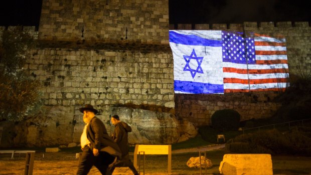 Israeli and American flags appear on the wall of the Old City of Jerusalem. This week, President Donald Trump upended decades of American policy by recognising Jerusalem as Israel's capital.