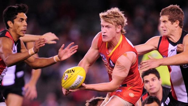 The Sun's Josh Caddy handballs away from St Kilda's Nick Dal Santo.