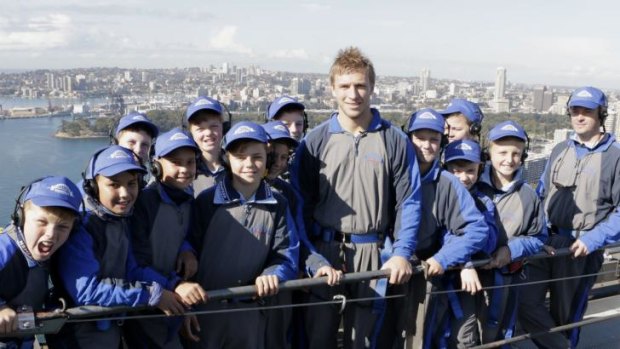 Sydney Swans Kieren Jack with members of the NSW Under 12 AFL team on top of the Harbour Bridge on Tuesday. Photo: Bridgeclimb.com