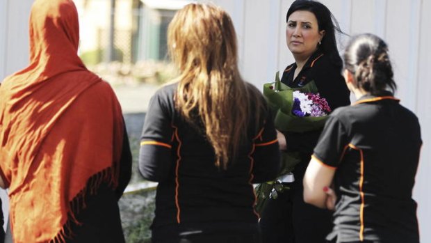 Tragedy ... a woman brings flowers to the site of the fire.