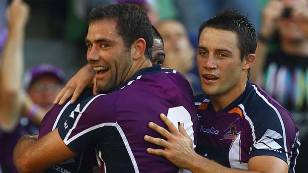 Sika Manu, Cameron Smith and Cooper Cronk of the Storm celebrate a try.