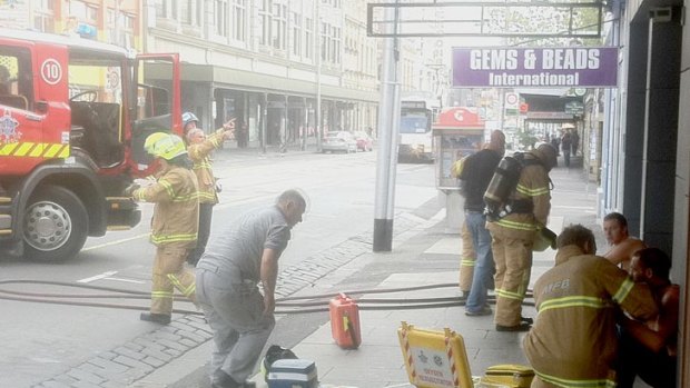 Firefighters treat two men at the scene of the explosion.