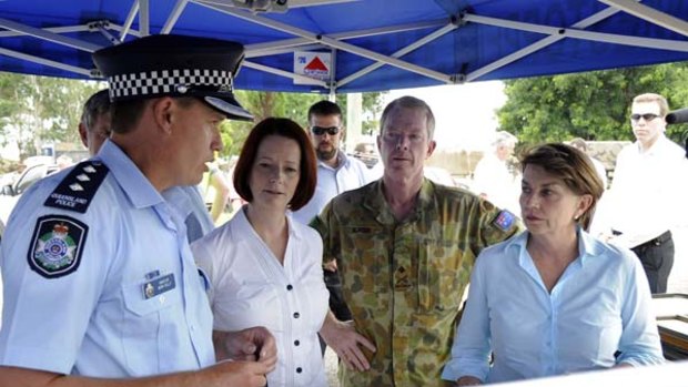 Queensland Police Inspector Mark Kelly briefs Julia Gillard, Anna Bligh and the Head of the Queensland Flood Recovery Task Force, Major General Mick Slater.