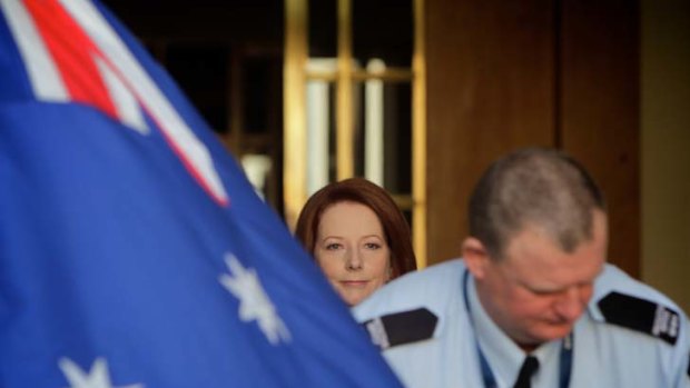 A lot can happen in a year ... an AFP officer opens the doors at Parliament House for the Prime Minister, Julia Gillard.