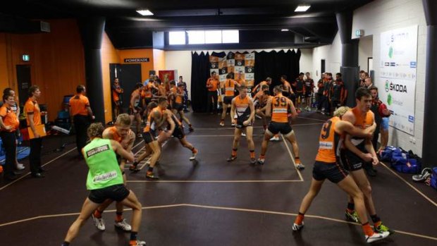 Warming up: Inside the dressing room of the GWS Giants team before the match starts, inset, Kevin Sheedy is expressionless during the game.