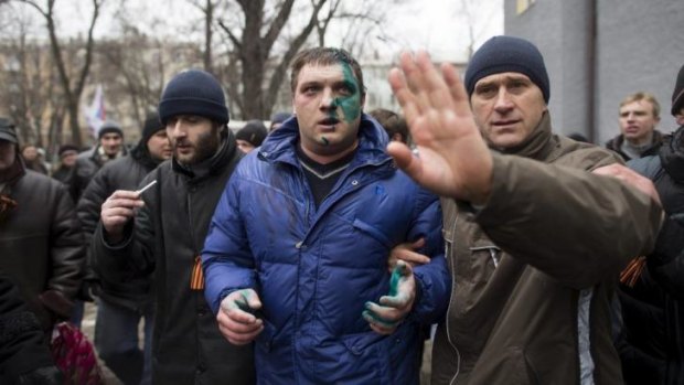 Protesters detain a man believed to be a member of parliament in Donetsk.