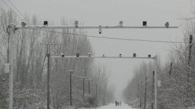 Big brother: Surveillance cameras keep watch on the roads entering Pilal village in Xinjiang.