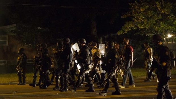 Police officers patrol a street in Ferguson, Missouri. 