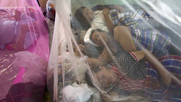 Thais rest under mosquito nets at a makeshift evacuation centre as flooding causes havoc in Ayutthaya.