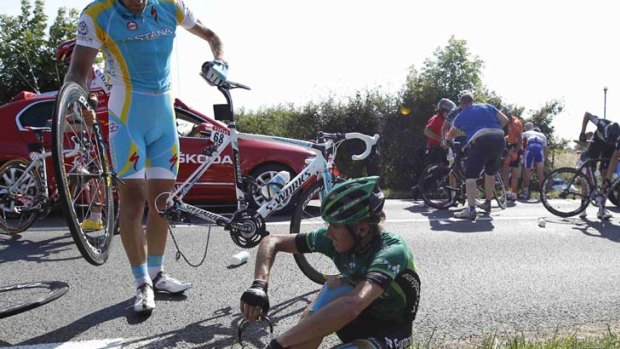 Europcar rider Vincent Jerome of France is assisted after a crash in the first stage.