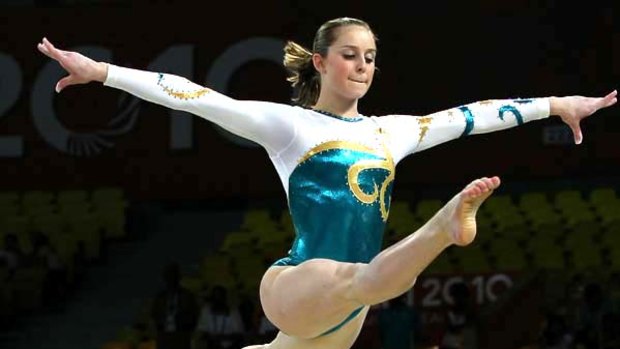 Gold start  . . . Australia's Lauren Mitchell takes to the air during her beam routine in Delhi.