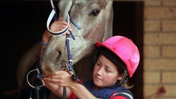 Michelle Payne putting the bridle on her horse in 2001.