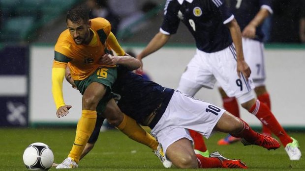 Hang on a second: Scot Charlie Adam drags down Socceroo Carl Valeri.