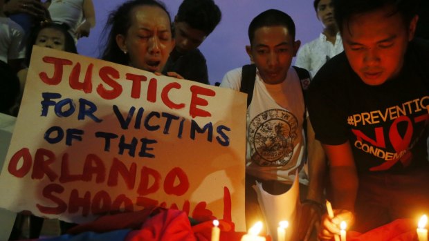 Filipinos light candles during a vigil to pay tribute to the victims of the Orlando, Fla. mass shooting.