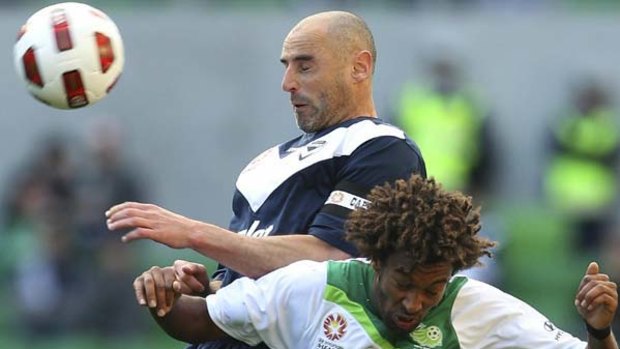 Melbourne Victory's Kevin Muscat heads the ball during the match against North Queensland Fury.