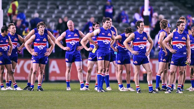 Shattered dreams: Exhausted Bulldogs ponder their loss in the crucial round 21 game against Essendon on Saturday night.