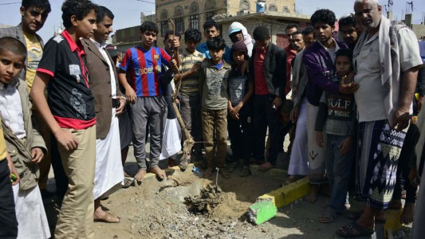 Yemenis gather at the site of a bomb explosion that targeted an army troop vehicle.