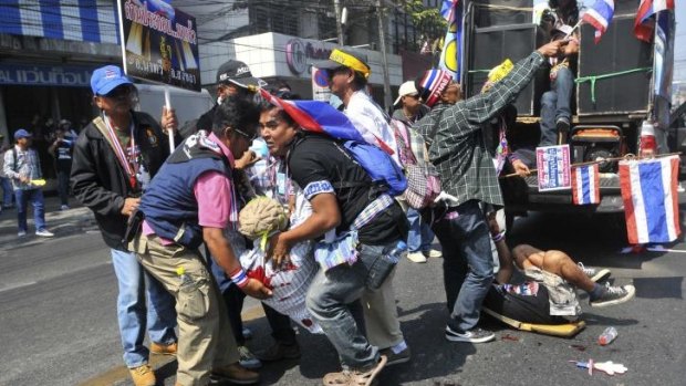 Grenade attack: Anti-government protesters help to take the injured to safety.