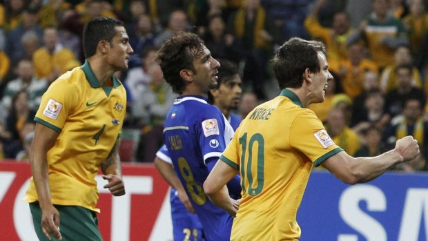 Tim Cahill (lef) reacts after scoring Australia's opening goal.