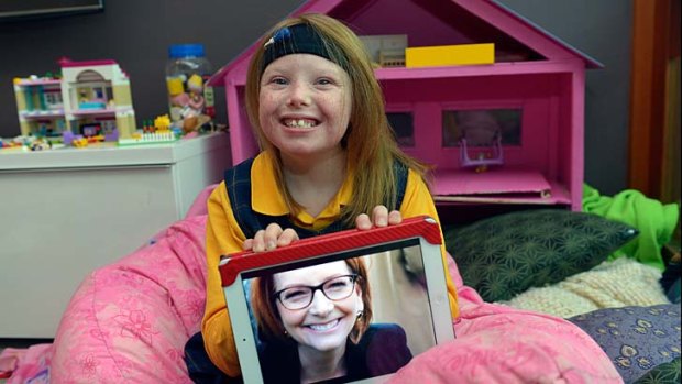 Little girl with a big impact: Sophie Deane holds up a photo of Julia Gillard.