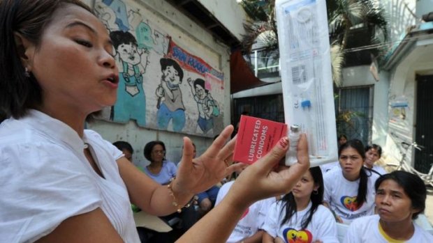 A Philippine health worker holds samples of contraceptives during a lecture to women in 2011.